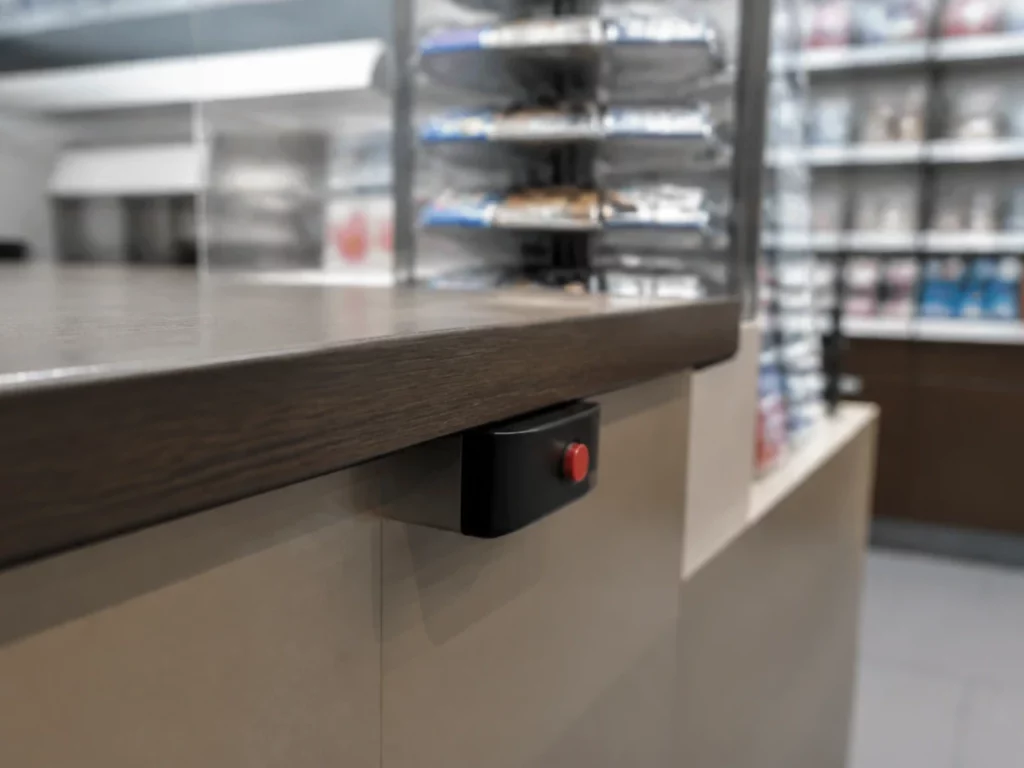 Bouton d’alerte fixé sous le plan de travail d’un comptoir de bureau de tabac