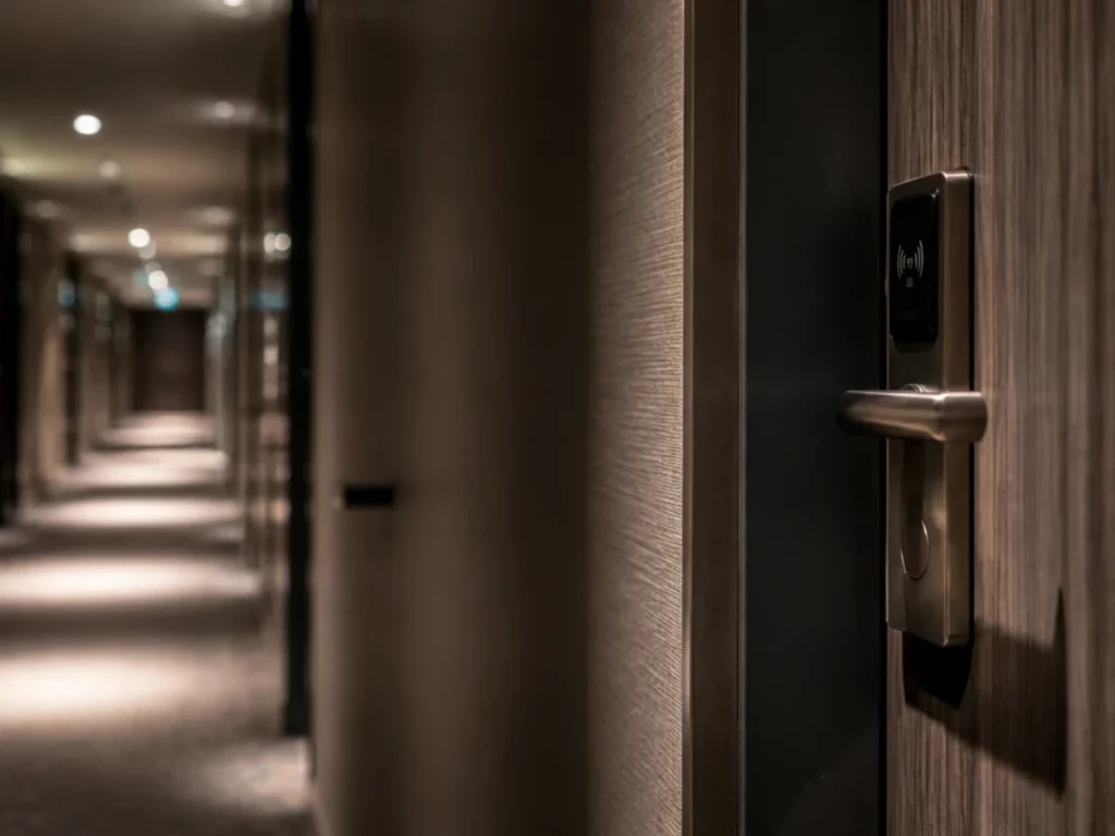 Lecteur de badge sans contact sur la poignée d’une porte de chambre, dans un couloir d’étage d’hôtel