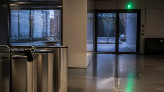 Hall de bureaux équipé d’un lecteur de badge et d’un bloc d’éclairage de sécurité au-dessus de l’issue