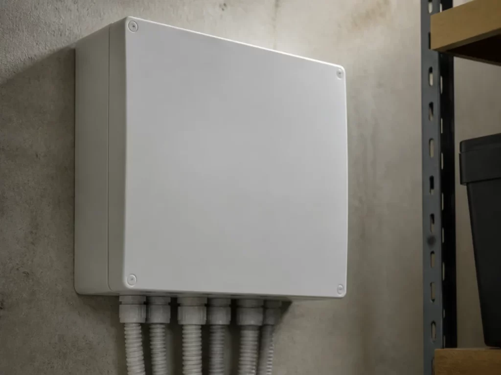 Centrale d’alarme fermée et gaines de raccordement dans un local, matériel d’une alarme intrusion