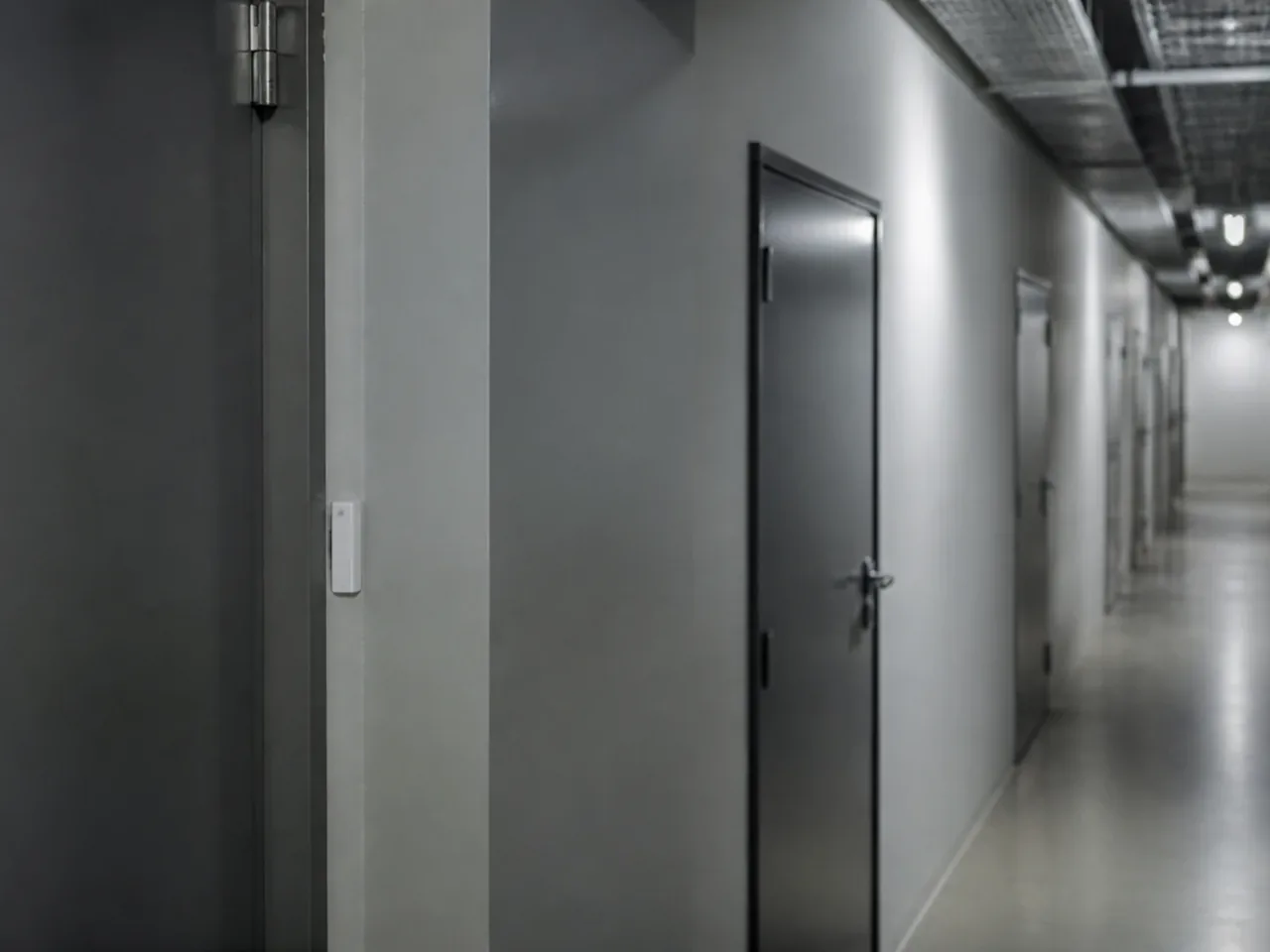 Couloir de service à l'arrière des boutiques d'un centre commercial avec des portes de réserve métalliques